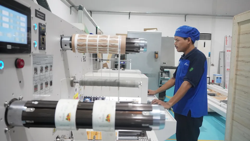 Operator mengoperasikan mesin finishing roll label